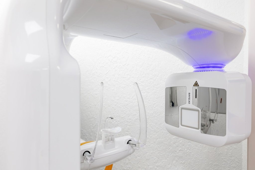 Close-up of dental imaging or curing light equipment with blue LED illumination and modern white device casing
