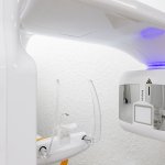 Close-up of dental imaging or curing light equipment with blue LED illumination and modern white device casing